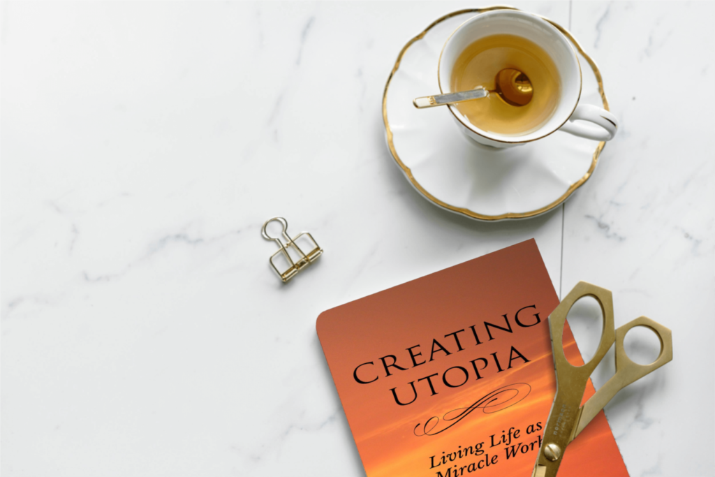 A book sitting on top of a table next to a cup.